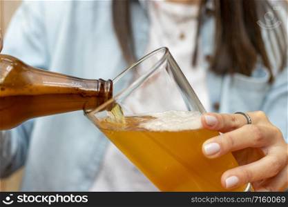 Woman serving a beer in a glass cup