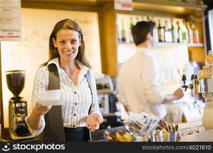 Woman serving coffee in cafe