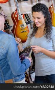 Woman serving customer in musical instrument shop