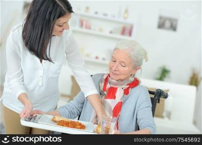 woman serving meal to injured woman