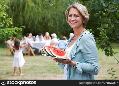 Woman Serving Watermelon at Garden Party