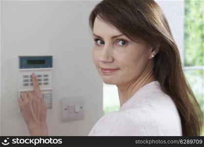 Woman Setting Control Panel On Home Security System