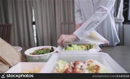woman setting up food table, take home food, delivery service, recycle disposable food package, food Delivery service application, healthy diet Vegetables Salad, new normal take away meal, new normal