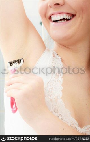 Woman shaving armpit armhole with razor shaver. Young girl removing underarm hair. Hygiene.. Woman shaving armpit with razor shaver. Hygiene.