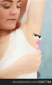 Woman shaving armpit with razor shaver. Hygiene.. Woman shaving armpit armhole with razor shaver. Young girl removing underarm hair. Hygiene.