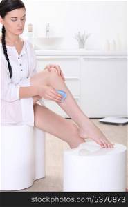 woman shaving her legs