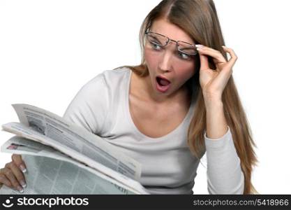 Woman shocked reading newspaper