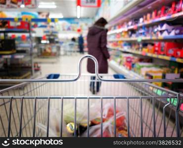 Woman shopping at the supermarket with trolley