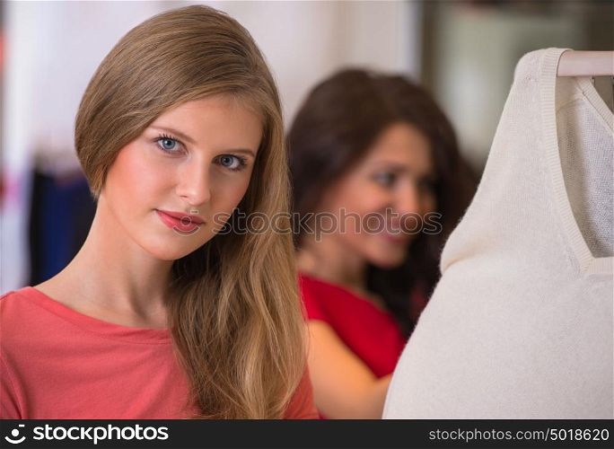 Woman shopping clothes. Shopper looking at camera indoors in store. Beautiful happy smiling caucasian female model.