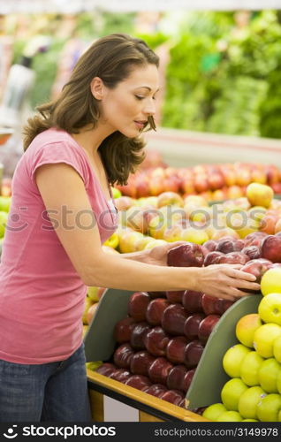 Woman shopping for apples at a grocery store