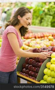 Woman shopping for apples at a grocery store