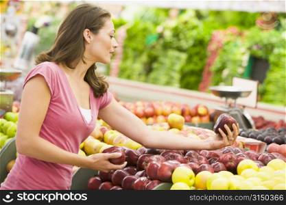 Woman shopping for apples at a grocery store