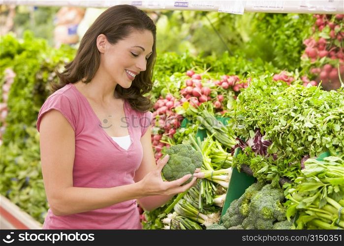 Woman shopping for broccoli at a grocery store