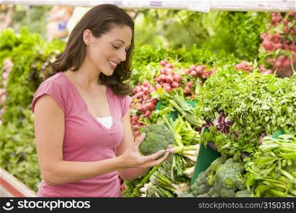 Woman shopping for broccoli at a grocery store