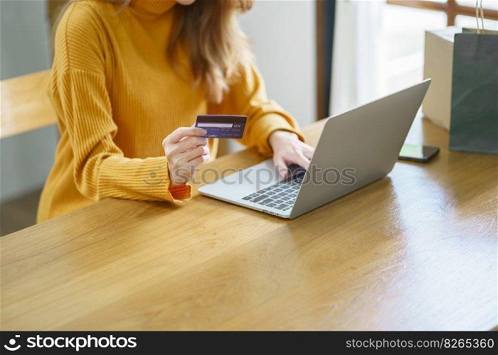 Woman shopping on laptop holding credit card for Internet online e-commerce shopping spending money Online shopping Mobile phone laptop technology