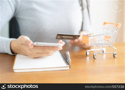 Woman shopping online in cart. Business woman hand using smart phone, payments and holding credit card online shopping.
