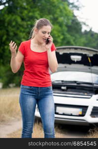 Woman shouting in mobile phone because of the broken car on rural road