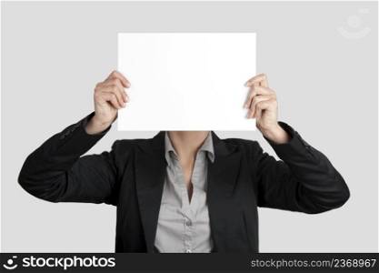 Woman showing a blank paper sheet in front of her head 