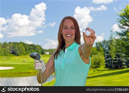 Woman showing a golf ball on the links