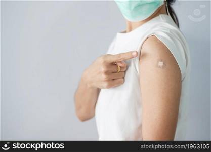 woman showing bandage after receiving covid 19 vaccine. Vaccination, herd immunity, side effect, booster, vaccine passport and Coronavirus pandemic