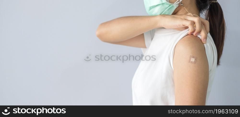 woman showing bandage after receiving covid 19 vaccine. Vaccination, herd immunity, side effect, booster, vaccine passport and Coronavirus pandemic