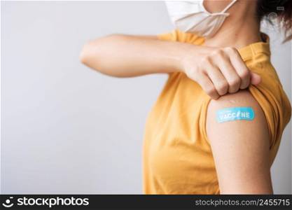 woman showing bandage after receiving covid 19 vaccine. Vaccination, herd immunity, side effect, booster dose, vaccine passport and Coronavirus pandemic