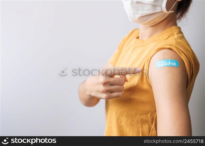 woman showing bandage after receiving covid 19 vaccine. Vaccination, herd immunity, side effect, booster dose, vaccine passport and Coronavirus pandemic