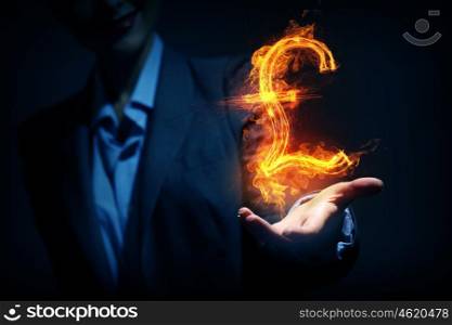Woman showing dollar symbol. Burning pound sign in businesswoman palm on dark background