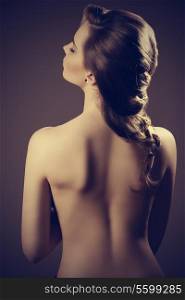 woman showing her sensual naked back and her elegant creative hair-style vintage color