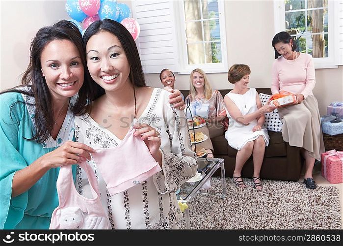 Woman showing off gift at baby shower