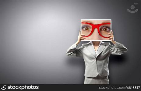 Woman showing photo. Unrecognizable businesswoman holding big photo with eyes