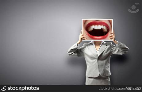 Woman showing photo. Unrecognizable businesswoman holding big photo with lips