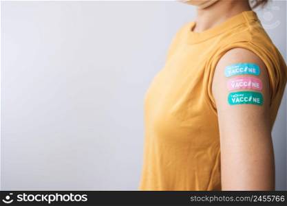 woman showing plaster after receiving covid 19 vaccine. Vaccination, herd immunity, side effect, booster dose, vaccine passport and Coronavirus pandemic