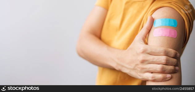 woman showing plaster after receiving covid 19 vaccine. Vaccination, herd immunity, side effect, booster dose, vaccine passport and Coronavirus pandemic