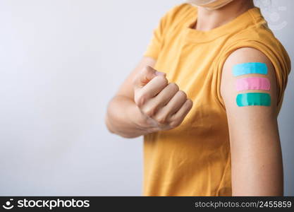 woman showing plaster after receiving covid 19 vaccine. Vaccination, herd immunity, side effect, booster dose, vaccine passport and Coronavirus pandemic