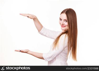 Woman showing presenting, long haired fashion girl uses hands to indicate area of frame, copy space for product, graphic, video or text. Presentation, advertisement concept. Studio shot isolated on white. Woman uses hands to indicate area of frame, copy space for product
