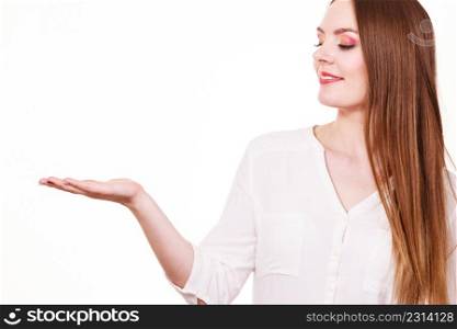 Woman showing presenting, long haired fashionable girl holding empty hand palm copy space for product. Beauty, fashion, advertisement concept. Studio shot on white background. Woman holds empty hand copy space for product