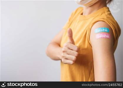 woman showing Thumb sign with bandage after receiving covid 19 vaccine. Vaccination, herd immunity, side effect, booster dose, vaccine passport and Coronavirus pandemic