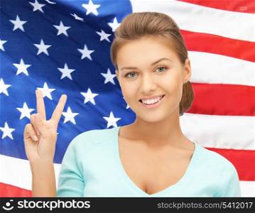 woman showing victory or peace sign over american flag