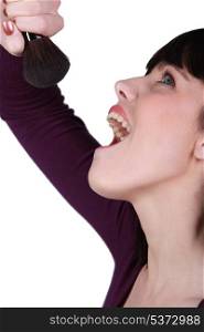 Woman singing into a blusher brush