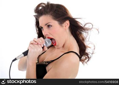 Woman singing loudly into a microphone