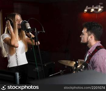 woman singing microphone guy playing guitar