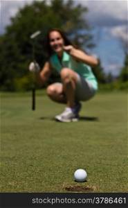 Woman sinking a putt on a golf green