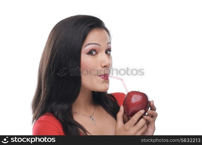 Woman sipping juice from an apple