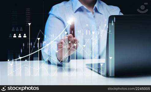 woman sits at a laptop in front of a holographic chart with growing indicators. Business development, high financial performance, success.