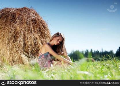 Woman sitting against haystack