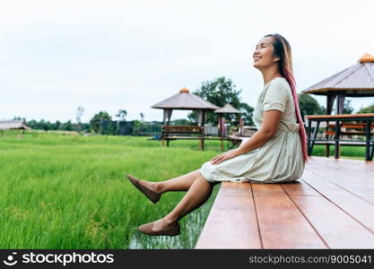 woman sitting and relax on Wood bridge with their legs hanging down