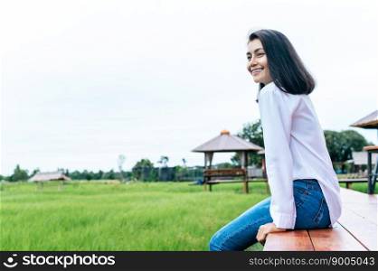 woman sitting and relax on Wood bridge with their legs hanging down