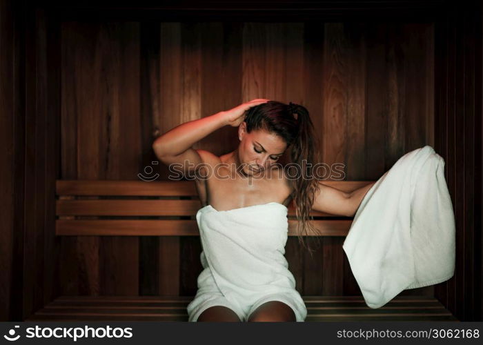 Woman Sitting and Relaxing in Hot Sauna.. Woman in Sauna