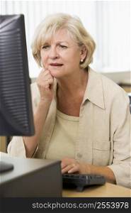 Woman sitting at a computer terminal upset (high key)
